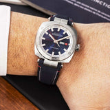 REF: 1764/42 Subtilement mise en relief par des surfaces polies et brossées, la forme coussin du boîtier en acier inoxydable 316L (42 mm de diamètre) rehausse le cadran au fond bleu. Cette montre est dotée d'un bracelet en textile. Très 70’s par sa grande ouverture Jour/Date à 3h, celui-ci n’est pas sans rappeler l’esthétique d’une boussole de navigation. Son étanchéité est efficace jusqu'à 100 mètres.